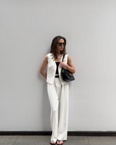 a lady wears a white suit vest with matching suit pants